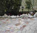 Flowerbed witk tumbled rocks in limestone